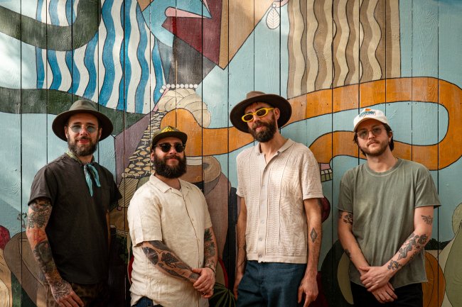 Coyote Island band members in front of a colorful wall